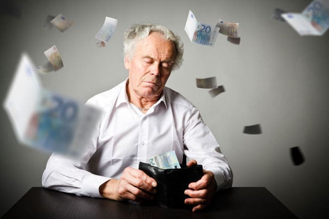 Retired man emptying wallet, bills flying through air