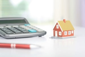 Calculator and pen with tiny model of house