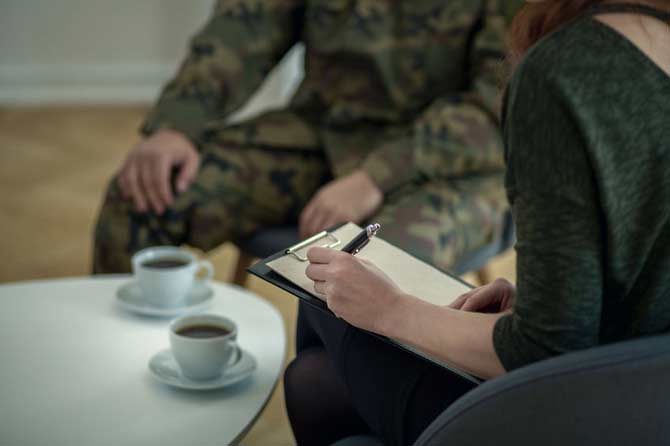 Soldier having coffee with someone filling out paperwork